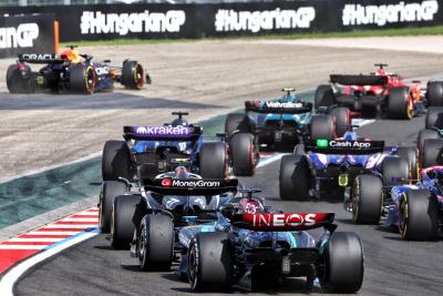 George Russell (GBR) Mercedes AMG F1 W15 at the start of the race as Max Verstappen (NLD) Red Bull Racing RB20 runs wide.